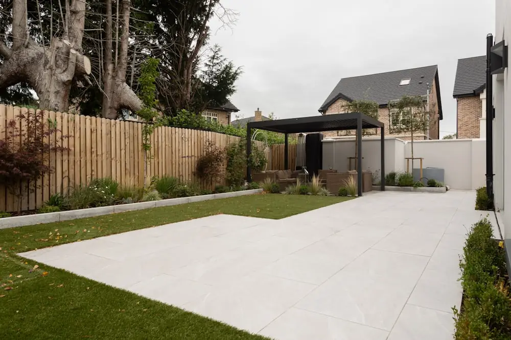 Modern backyard patio with a pergola, new lawn, and cedar privacy fence