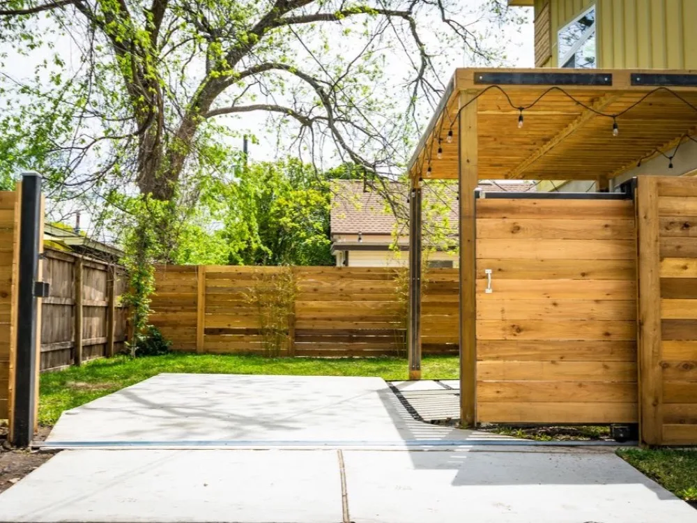 Modern horizontal-slat cedar privacy fence with a pergola