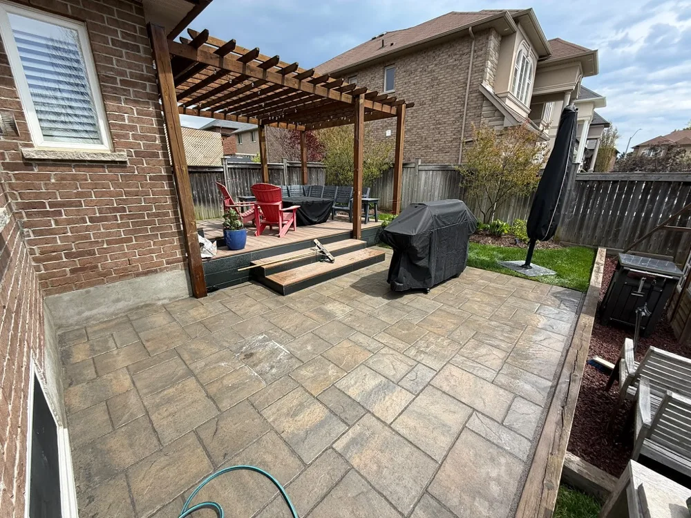 Restored stamped-look interlock patio with pergola in Ancaster, Ontario