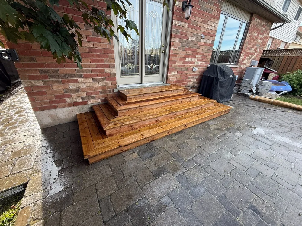 Backyard interlock patio restoration with new wood entry steps in Winona, Ontario